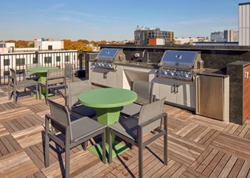 A patio with a table and chairs overlooking a cityscape.